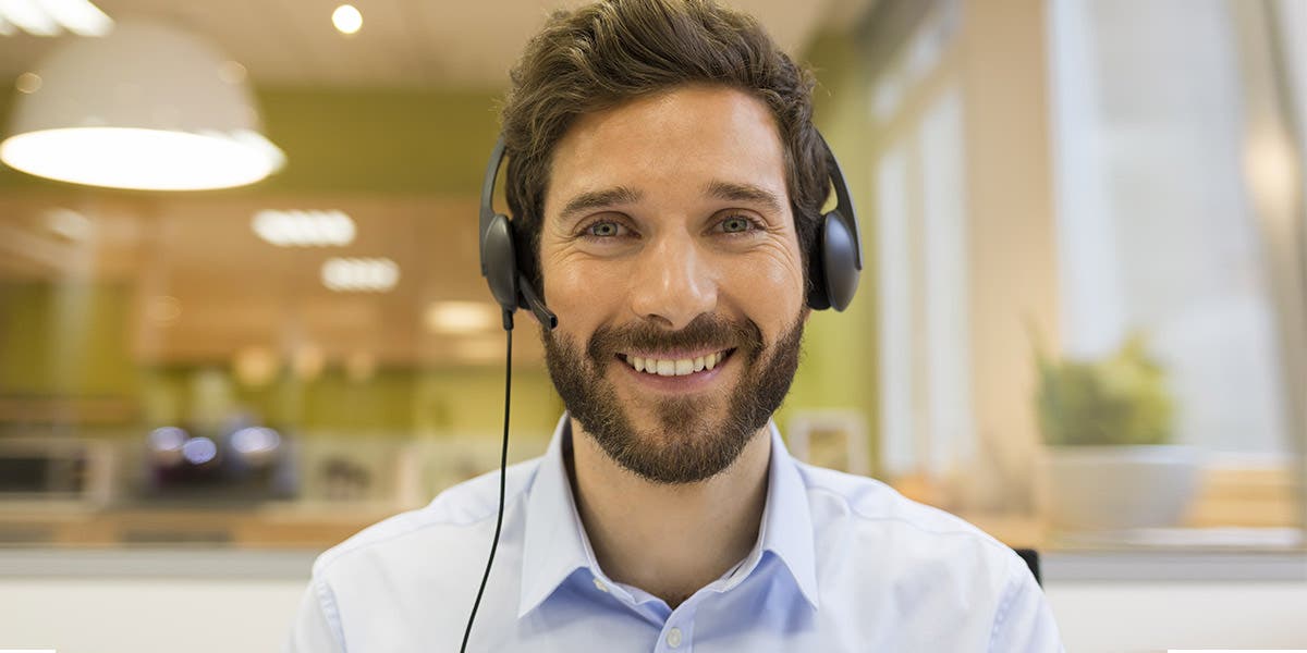 man working with a headset on, creating a successful virtual classroom experience
