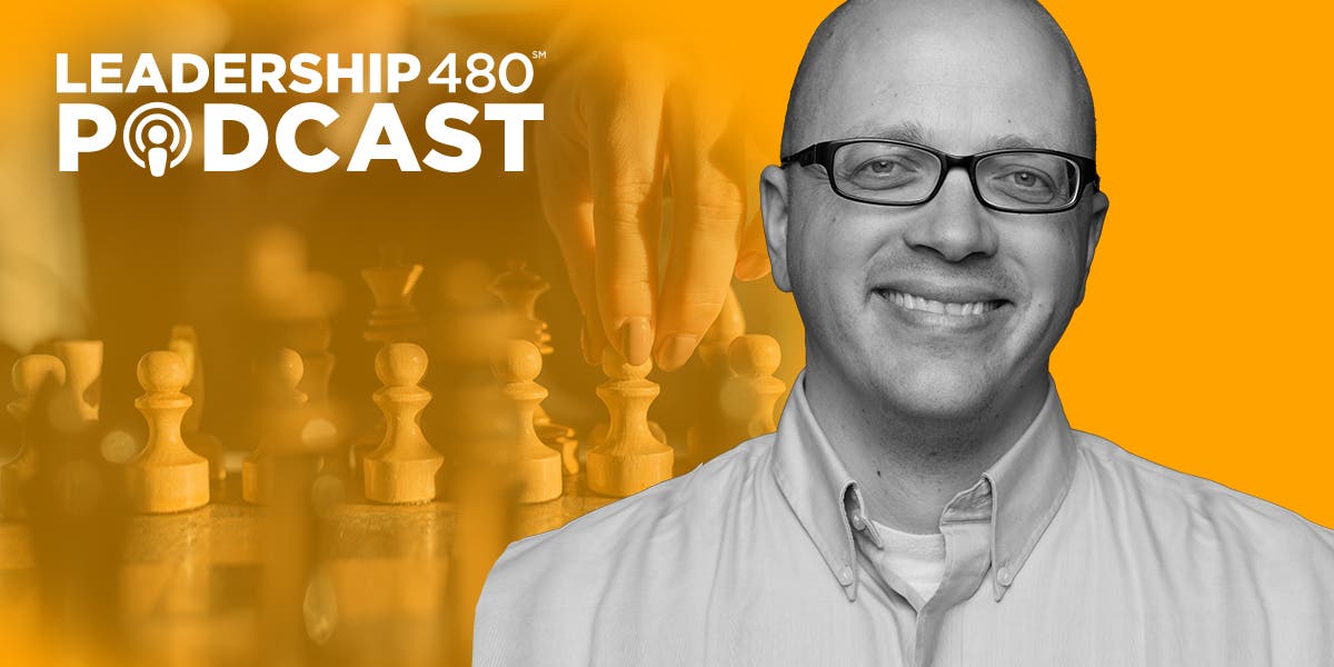photo of Tylder Ludlow with someone moving chess pieces in the background to show that this podcast episode is about how leaders can make better decisions, and be more strategic about their decision-making process