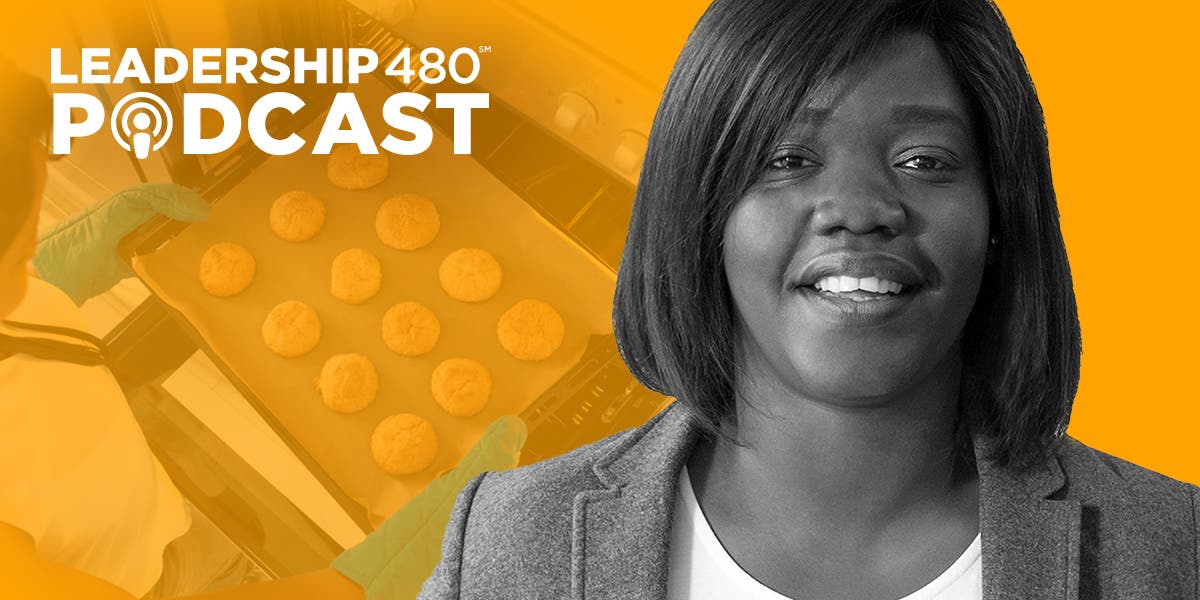 image of Leadership 480 podcast guest Hermine Dossou, with a person in the background getting a tray of cookies out of the oven to show that this episode is about leadership lessons from the Great British Baking Show