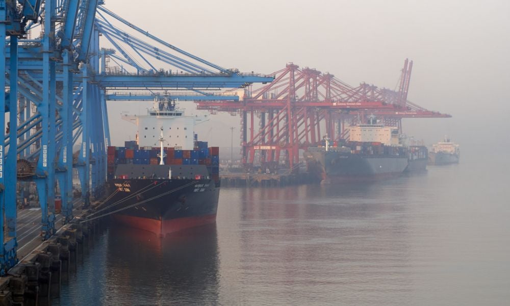 India, Mumbai Port Trust, with moored container vessels with port cranes during the morning fog.jpeg