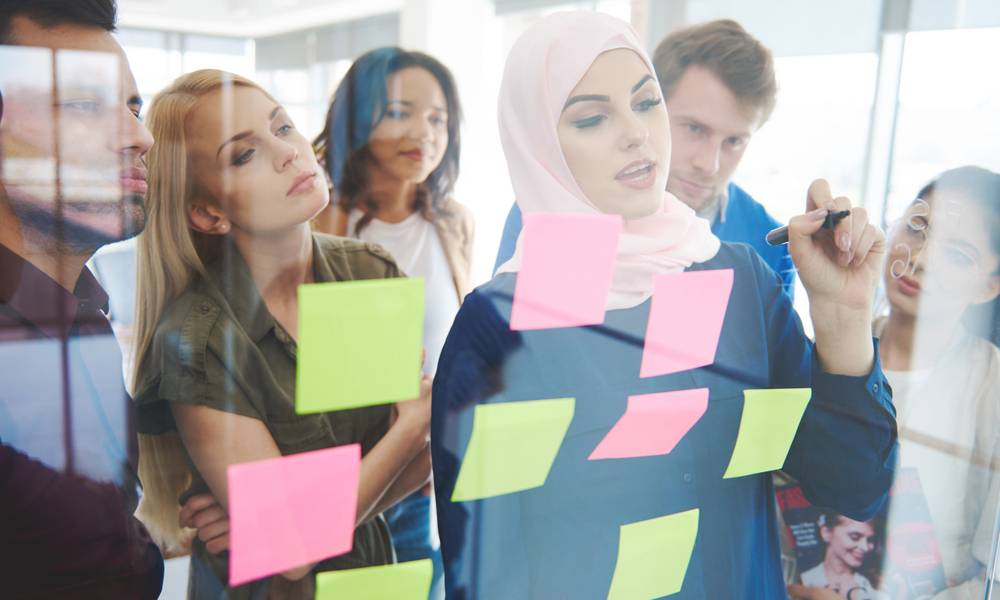 Business woman showing new blueprints to colleagues.jpeg