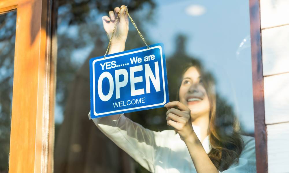 Woman holding open sign outside shop (1).jpg