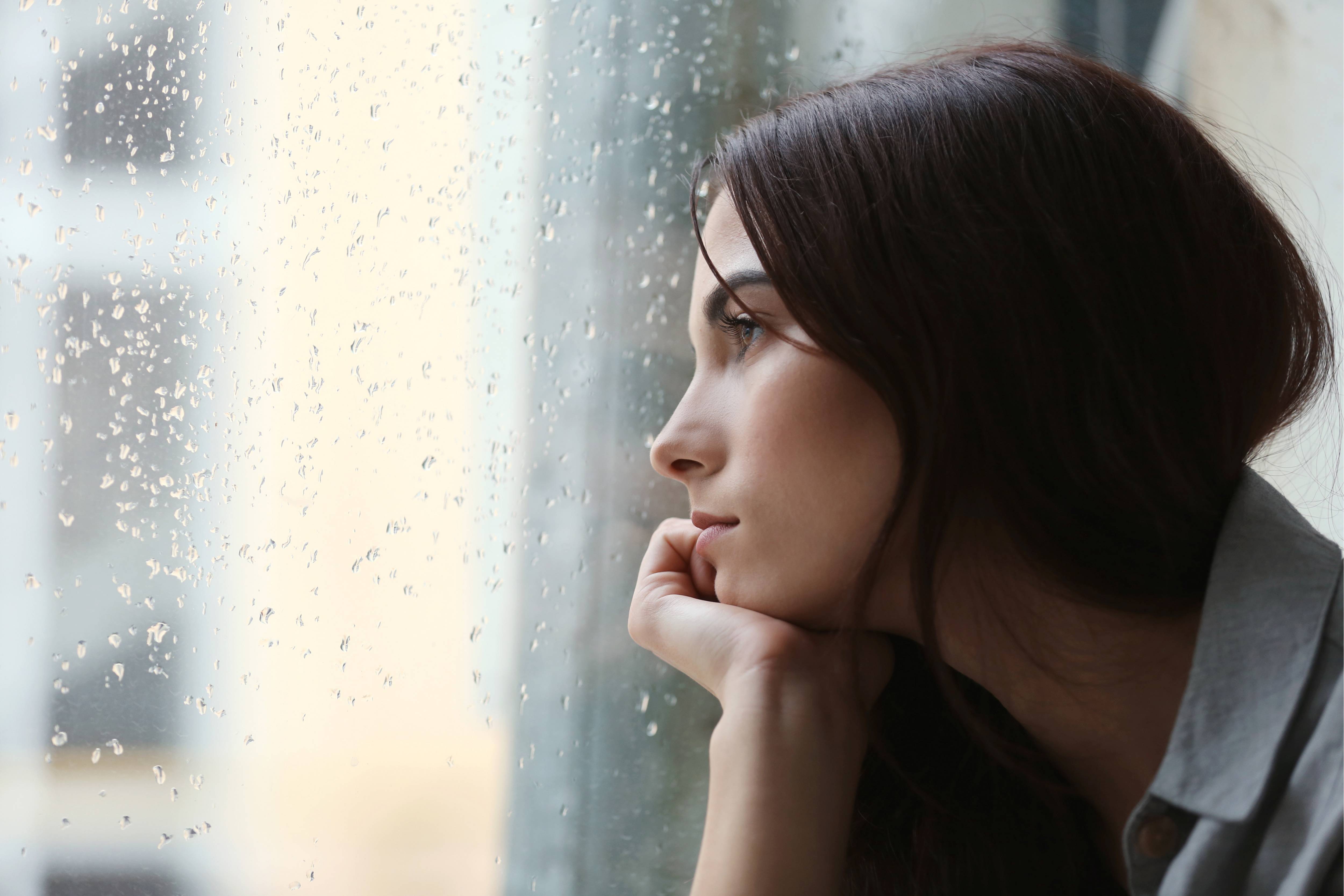 Woman stares out of window into the rain (1).jpg