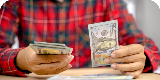 Counting out cash to send in a money order at CheckSmart.