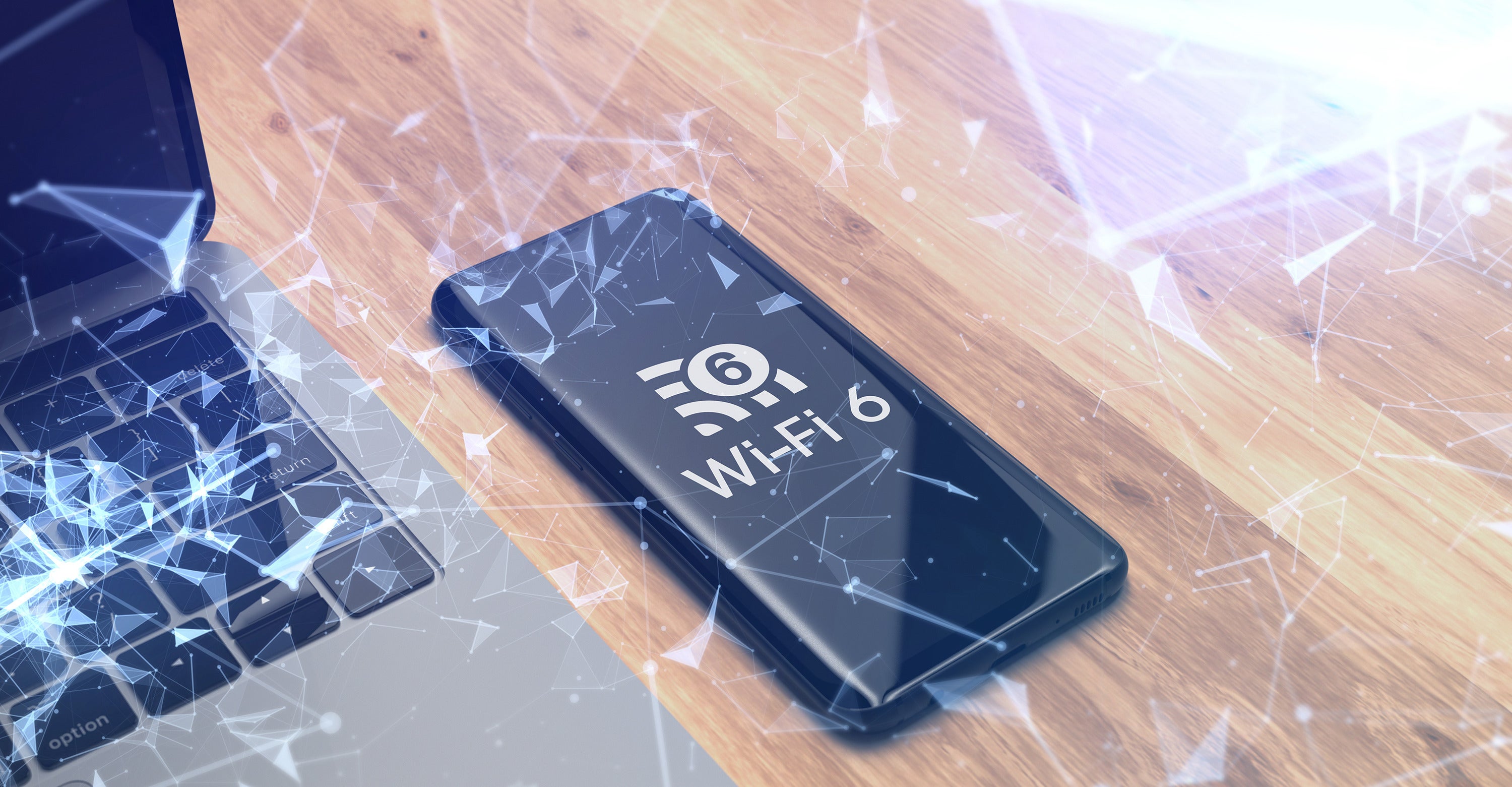 Smartphone displaying Wi-Fi 6 logo next to a laptop on a wooden surface.