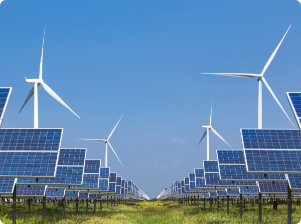 Solar panels and wind turbines under a clear blue sky.