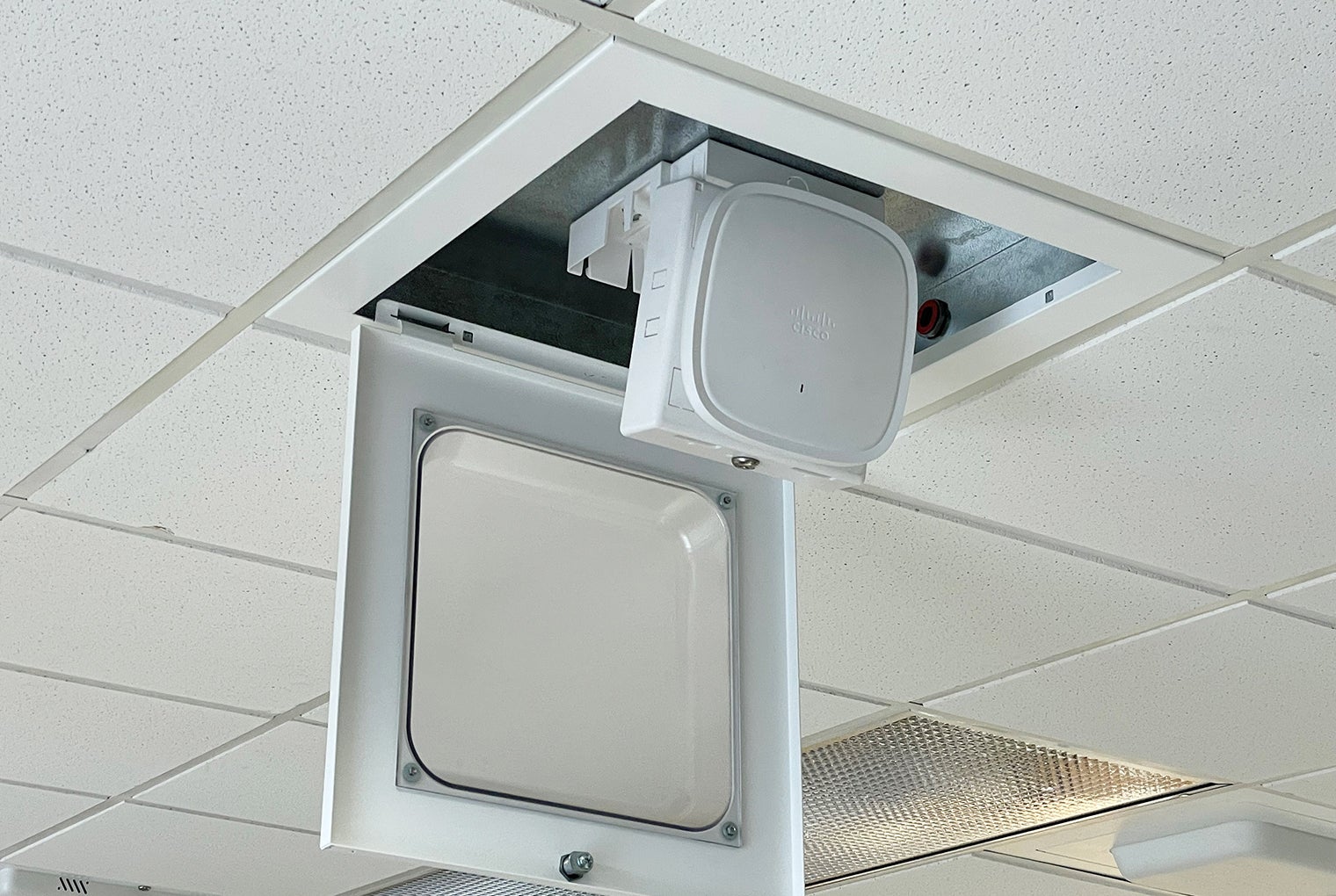 Ceiling-mounted device with a white cover and a Cisco logo.