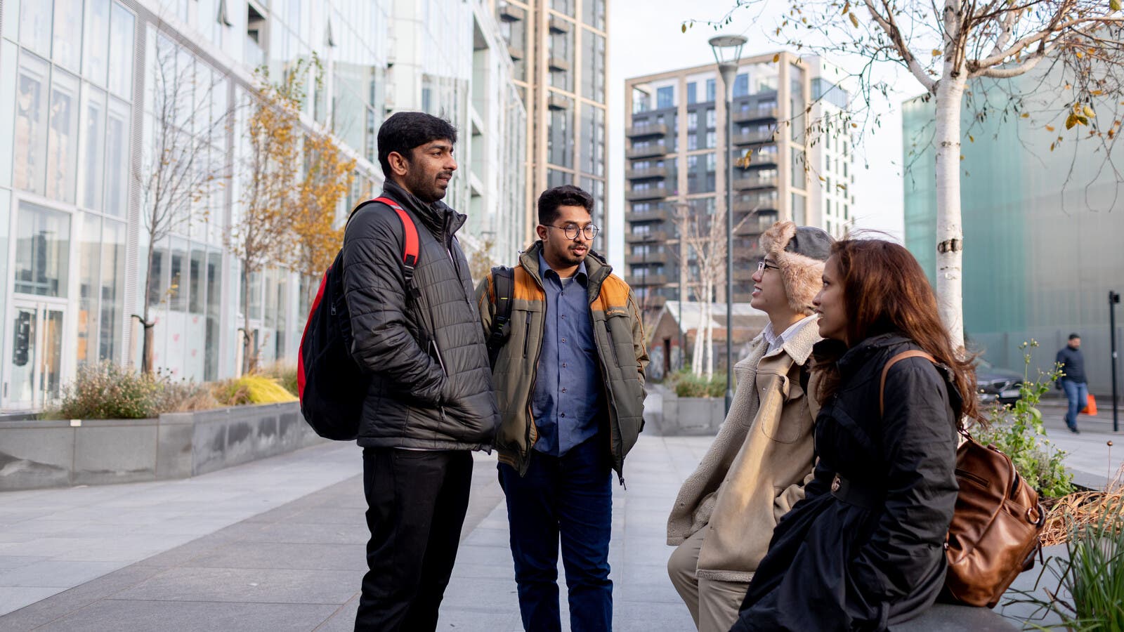 Four students outside campus chatting