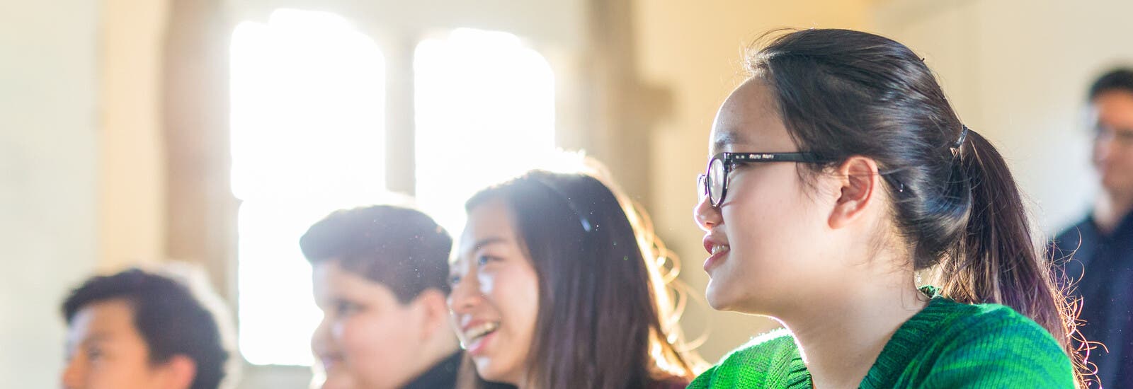 Students sat in a row in class smiling