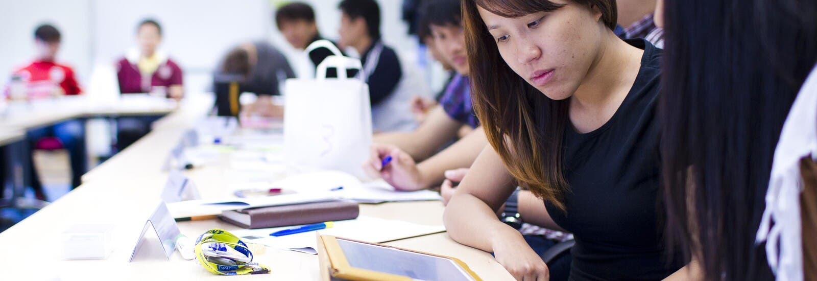 LJMU students looking at a tablet in class