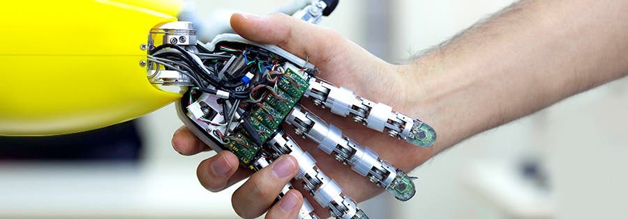 Student shaking hands with robot hand