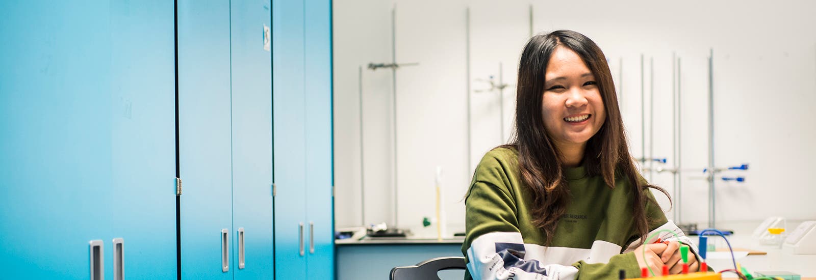 Student smiling while using computer