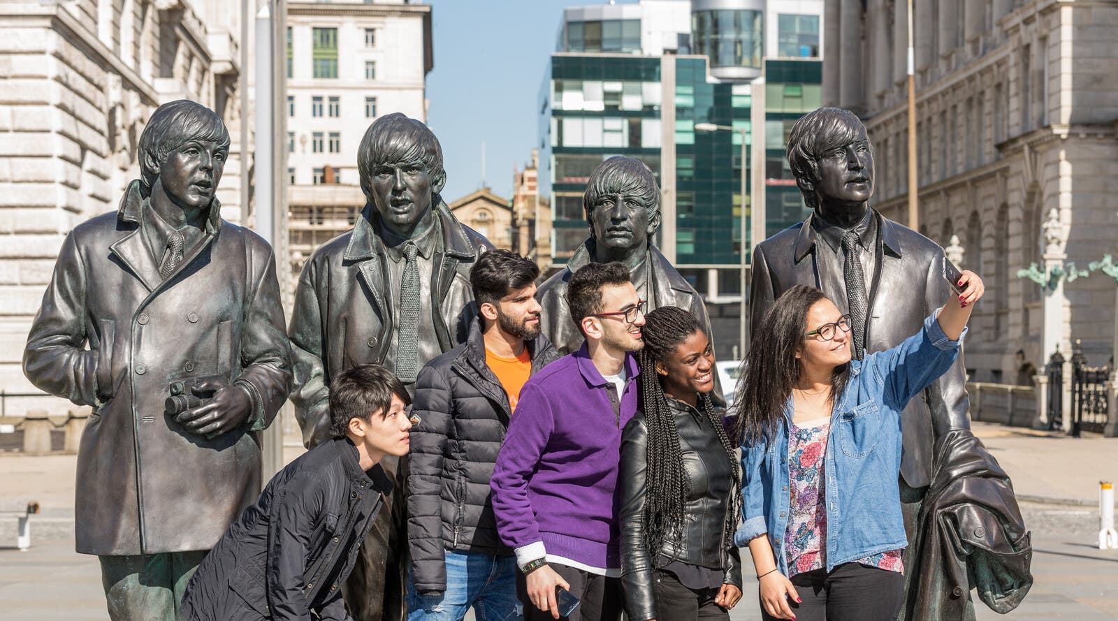 Students in front of a statue of The Beatles 