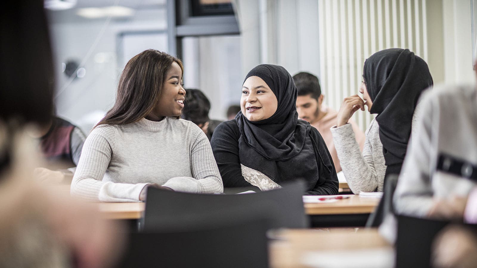 Two students smiling at each other in class