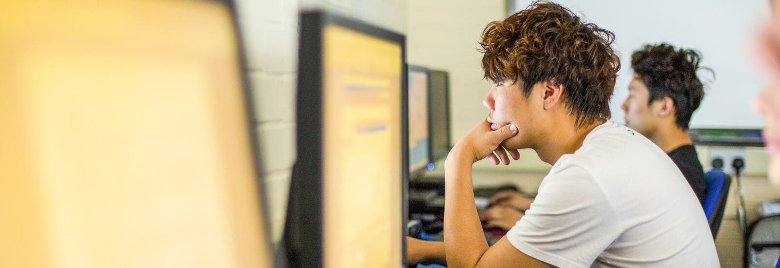 Student smiling in front of a group of students outside