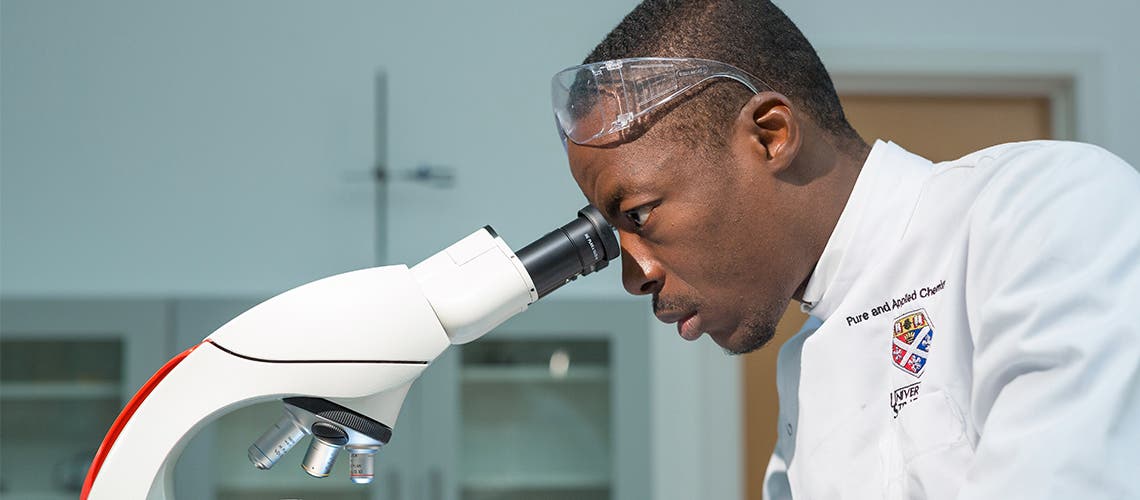 Strathclyde science student looking through microscope