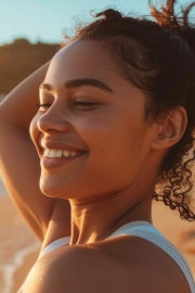 A woman on the beach enjoys the sunlight.