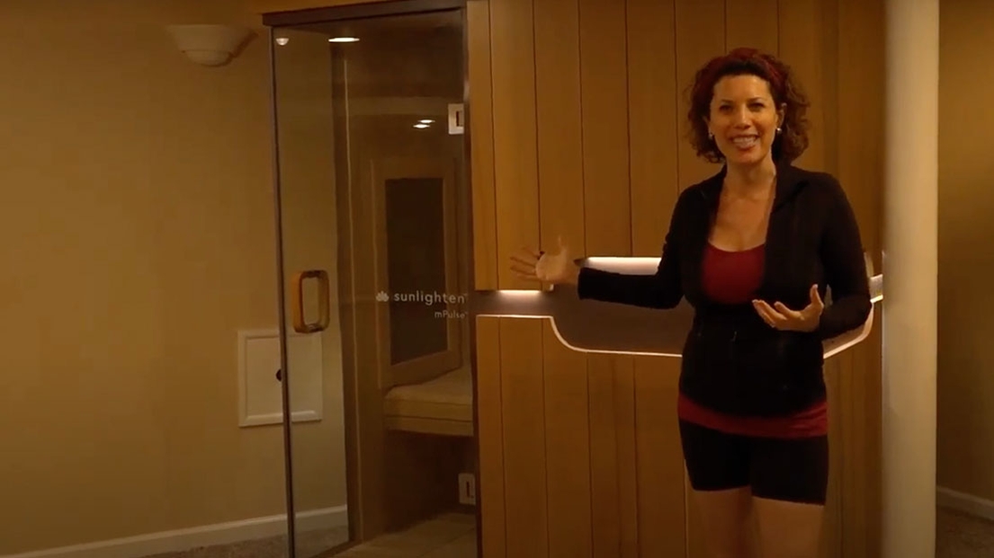 Susan Peirce Thompson standing by her Sunlighten sauna