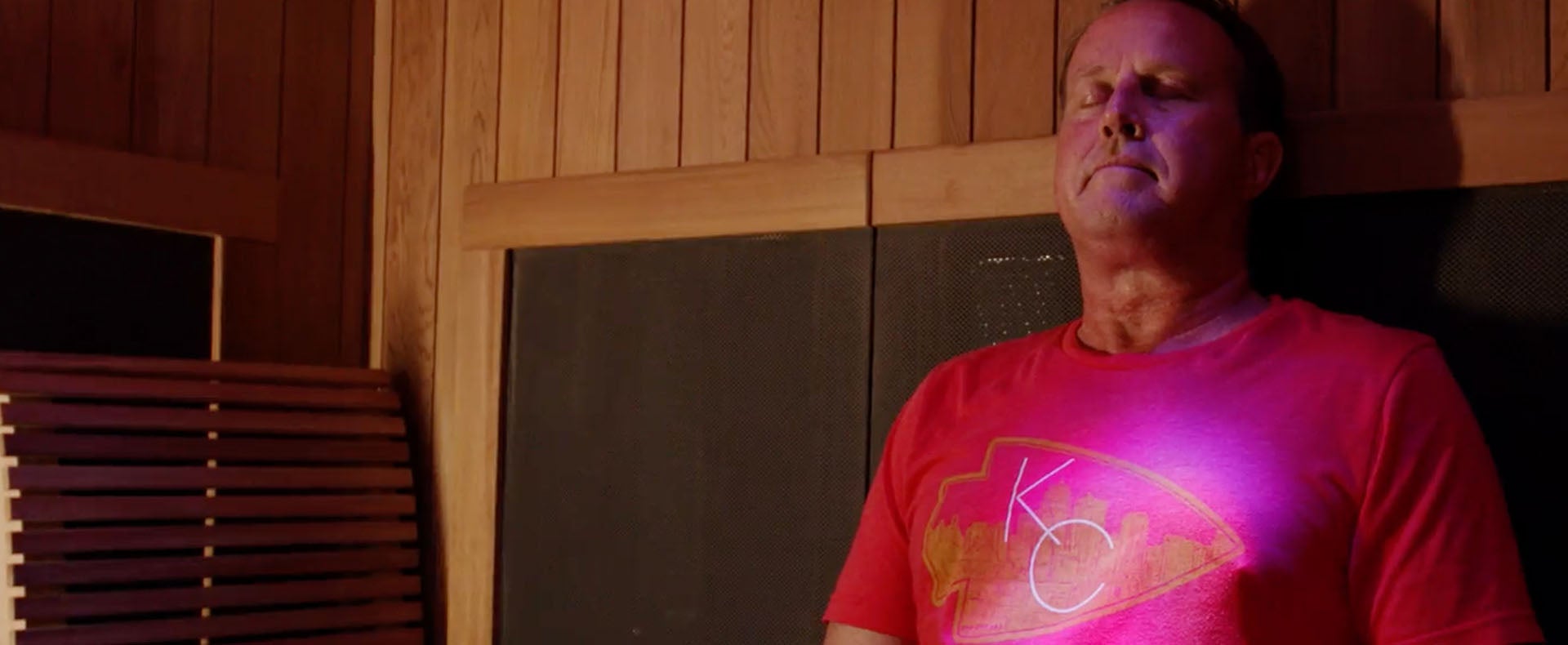 Darrell Mills sits in an infrared sauna with his eyes closed relaxing.