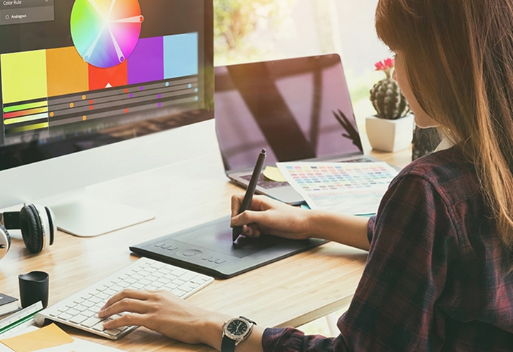 Woman at computer working on Marketing Promotional Assets