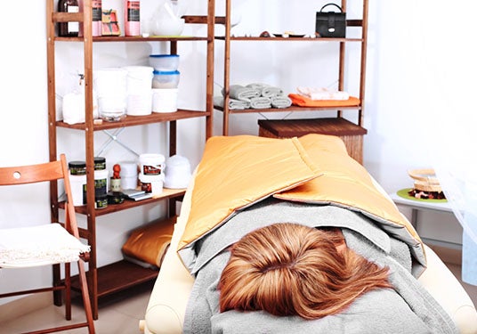 A person lays in an infrared sauna.