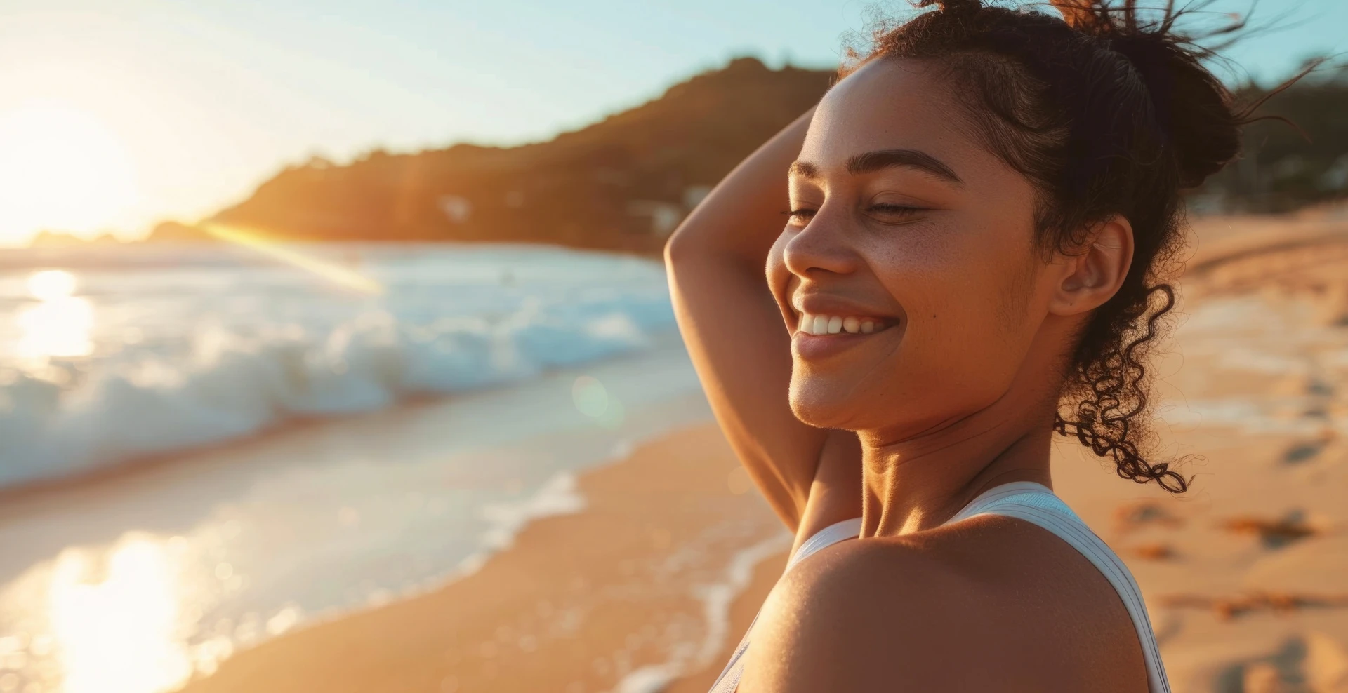 A woman on the beach enjoys the sunlight.