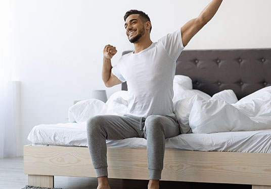 A man wakes up from a restful sleep after using a Sunlighten infrared sauna.