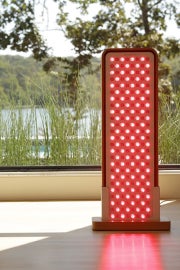 Sunlighten's RED Light Panel sits in front of a window.