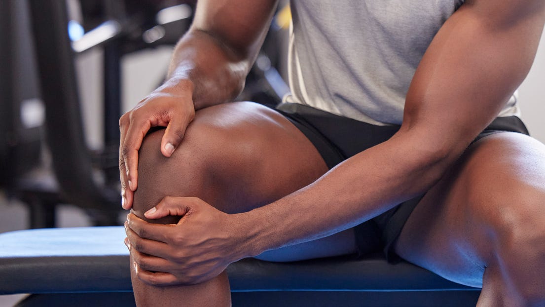A man rubs his knee after exercising.