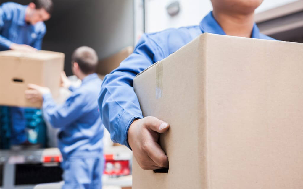 A close shot of mover carrying boxes out of a moving truck during a military PCS.