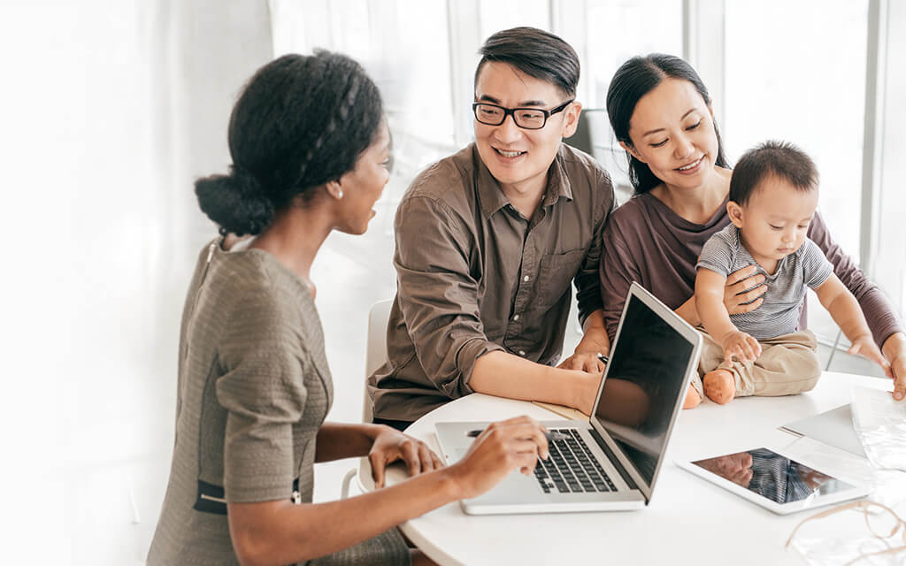 Image of a financial advisor speaking with a Dad, Mom and child.