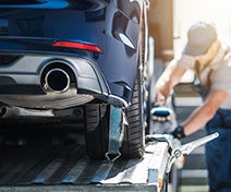 A man loading a vehicle into a shipping containers for a PCS.