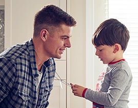 A man and a young boy in a kitchen.