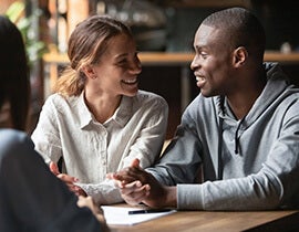 Woman smiling while sitting next to a man.