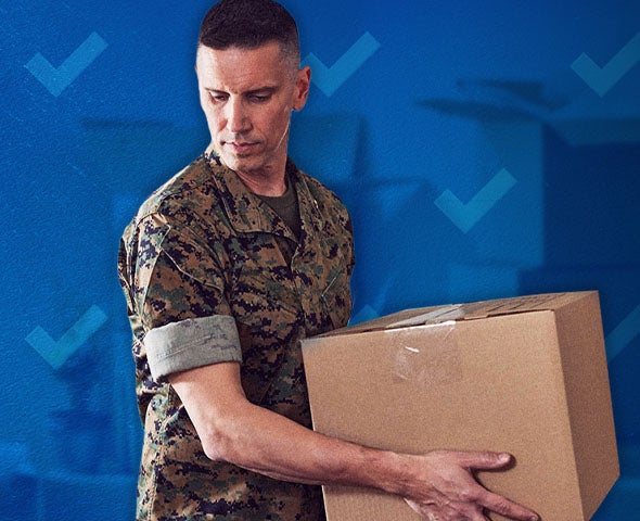 man in military uniform carrying a moving box