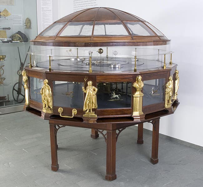 Joseph Pope orrery, completed in 1787, with brass busts and statuettes of Isaac Newon, Benjamin Fannklin, and James Bowdoin II around the base, repeated 4 times, now in the Putnam Gallery, Harvard Science Center; Franklin is the figure at center, Newton is the bust at right, and Bowdoin is to the left of Franklin. (chsi.harvard.edu)