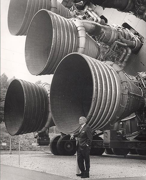 Wernher von Braun at the working end of a Saturn V rocket, with five F-1 engines, unused first stage at Marshall Space Flight Center, Huntsville, Alabama, photograph, early 1970s (Wikimedia commons)