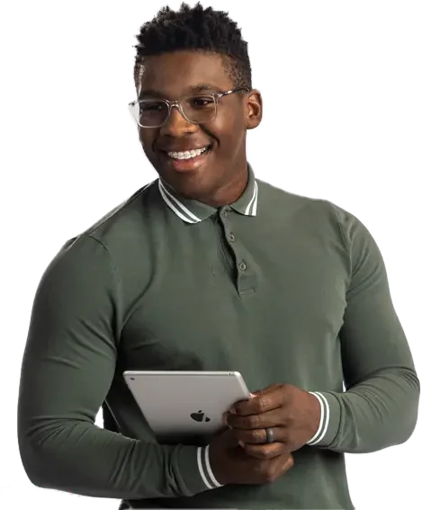 A man in a green shirt and glasses smiling while holding an iPad.