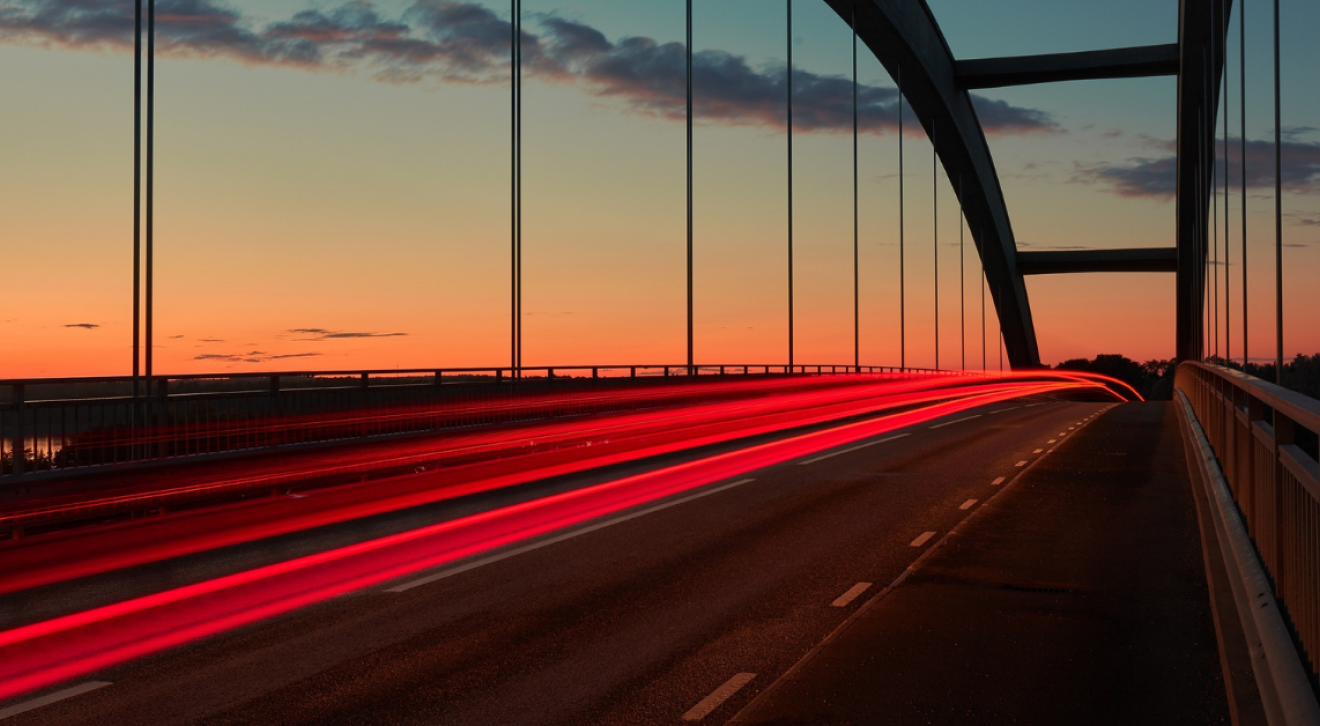 red light time lapse over bridge at sunset