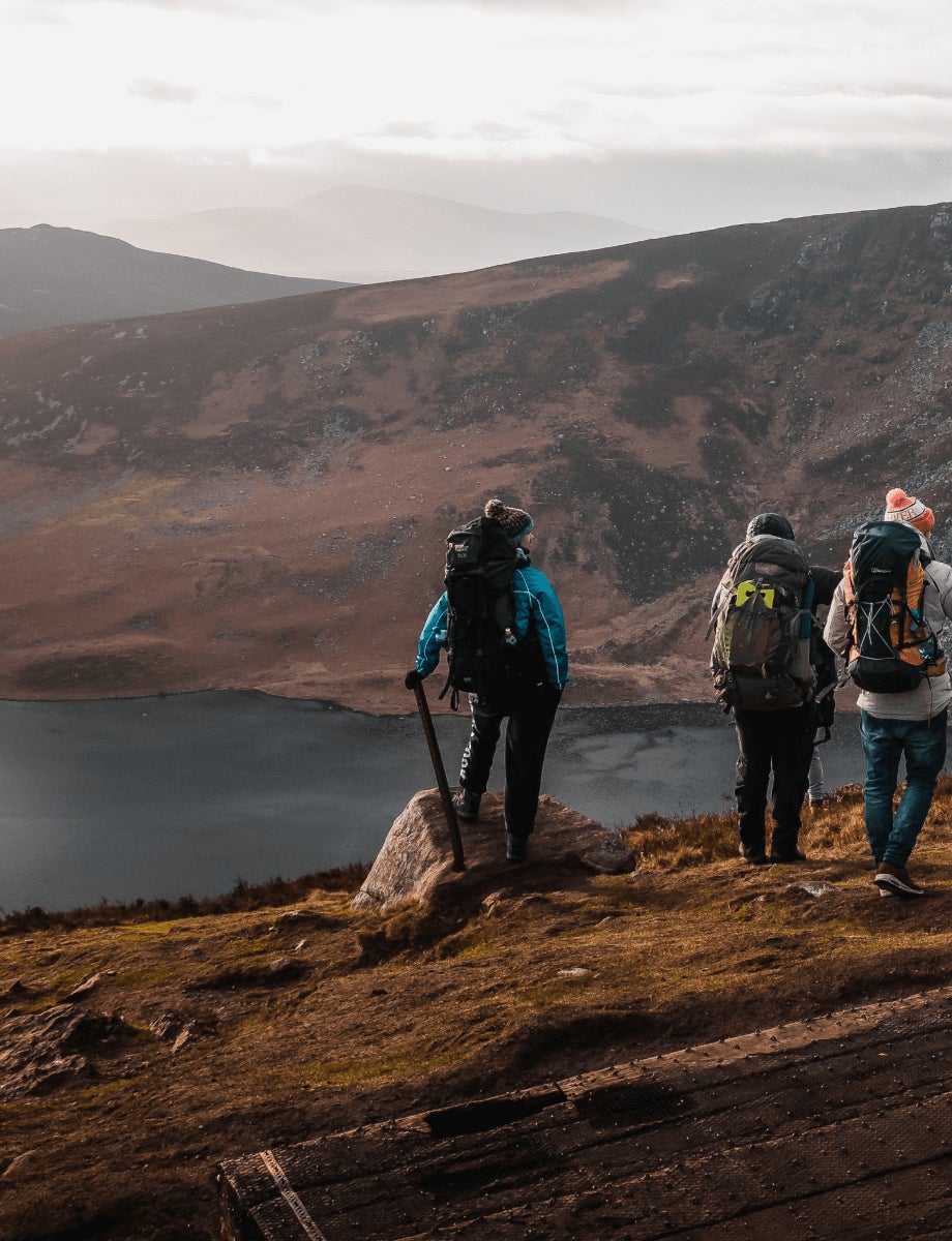 A group of hikers on a mountain looking down at the lake below