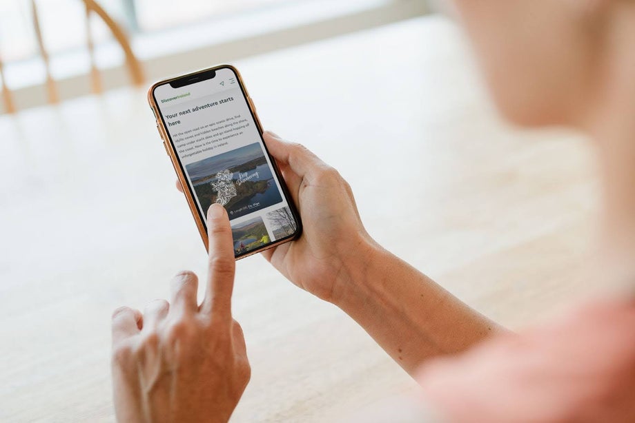 Person navigating the Discover Ireland website on their phone