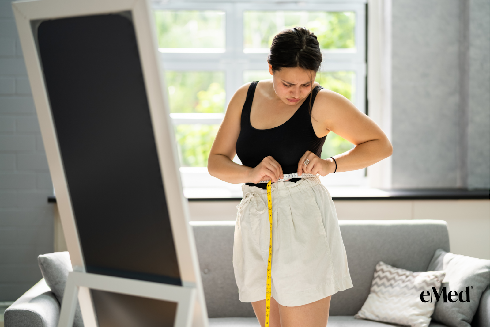 A woman checking her weight for weight loss and feeling challenged.